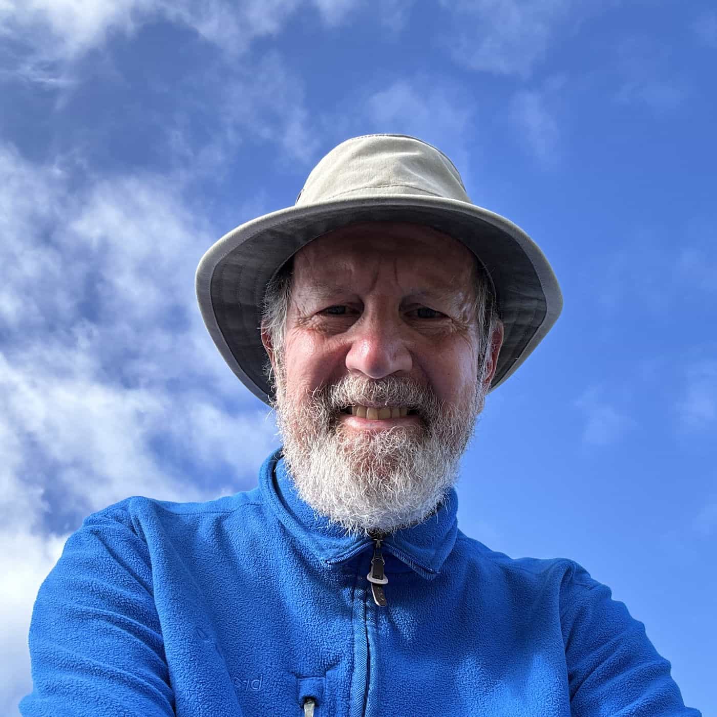 Geoffrey,  with a blue sky and fluffy white clouds behind him